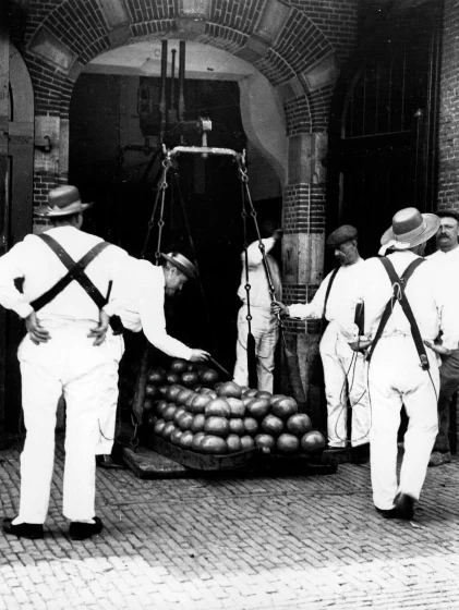 1910 - Traders weigh Dutch cheeses in the cheese market in Alkmaar, Holland. Source: F. J. Mortimer