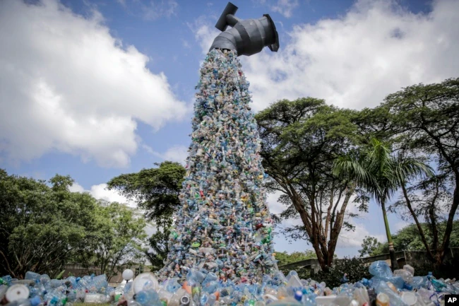 A giant art sculpture showing a tap outpouring plastic bottles