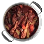 Stainless steel pot full of lamb shanks and vegetables.